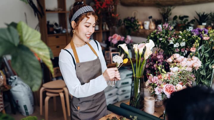 Young female florist in Santa Fe putting together a flower arrangement in a flower shop.