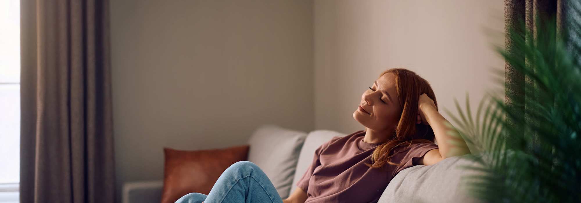 Woman sitting on a couch with a relaxed expression at Brush Factory Lofts in Philadelphia, Pennsylvania 