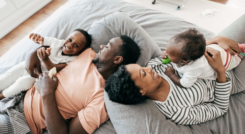 A mother and father laying in bed with their children at Mod Villas in Kingsland, Georgia