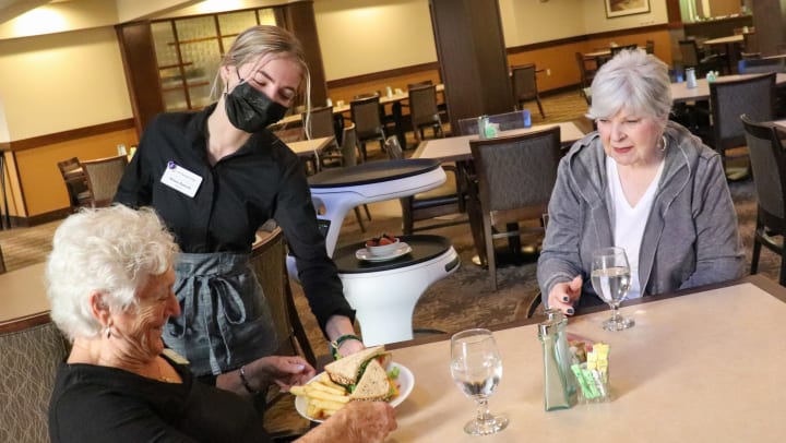 Woman serving seniors in a dining room