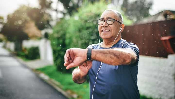 Man jogging while checking his smartwatch.