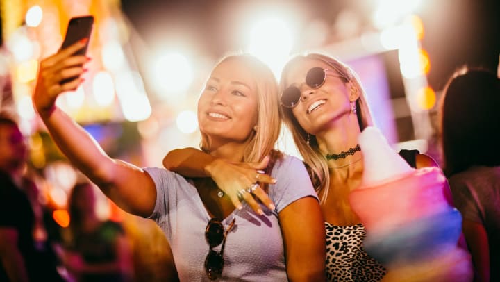 Two women take a selfie together at a concert