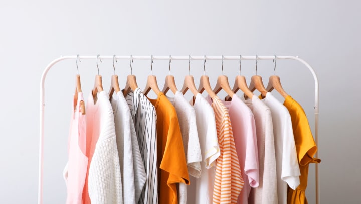 Fashion clothes on a rack in a light background indoors.