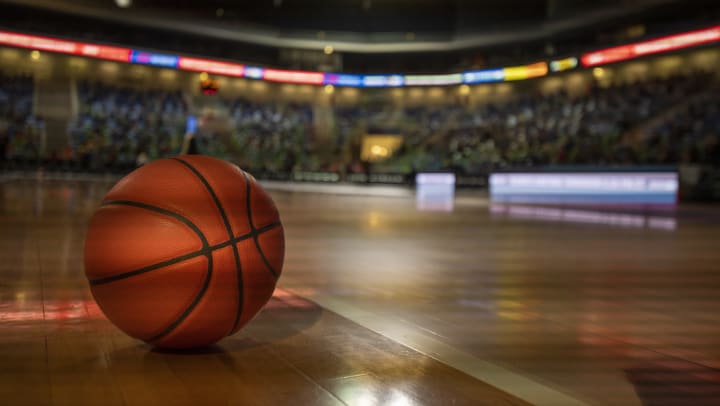 A basketball on a court inside an arena