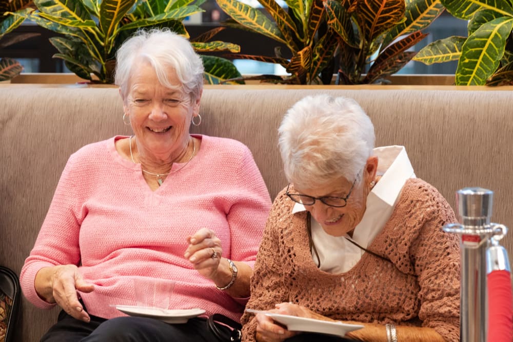 Residents laughing while having a snack and beverage together at Anthology of Mason in Mason, Ohio
