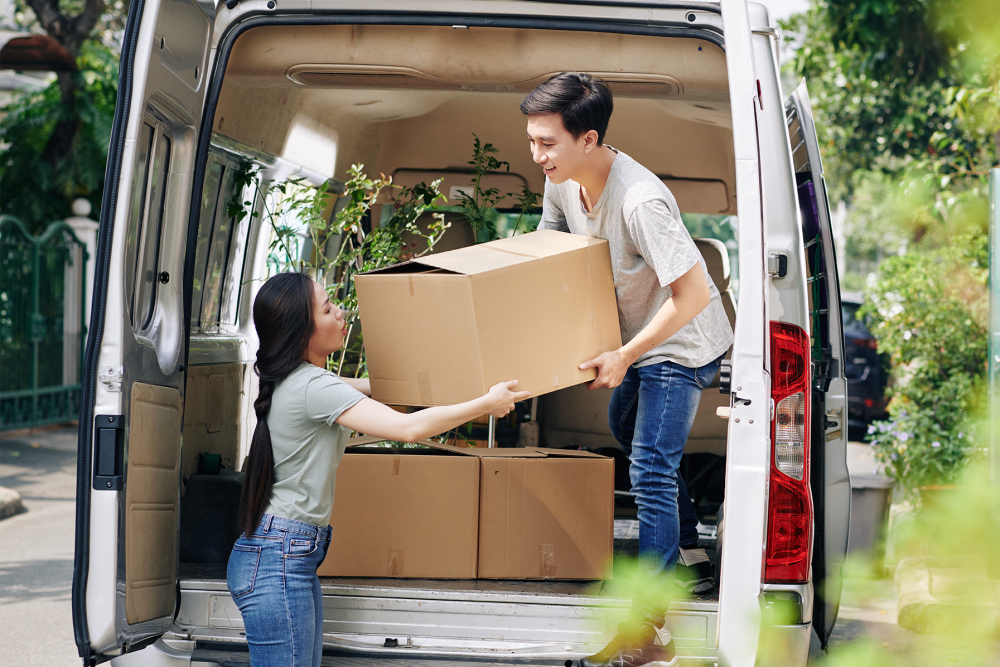 Two people unloading boxes from the back of a van at A-American Self Storage in Pomona, California