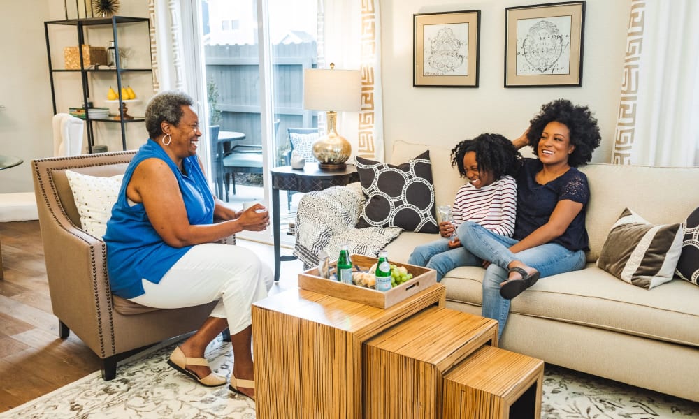 Family conversing happily on the couch at Dragas Home Rentals in Virginia Beach, Virginia