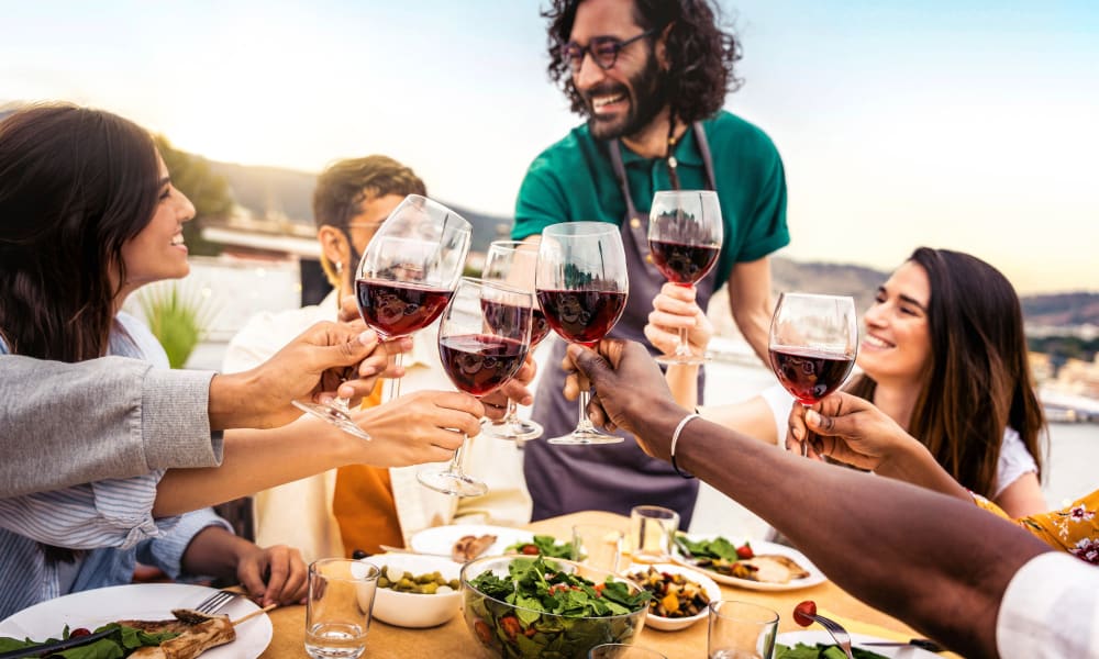 A group of friends holding their wine glasses together in a restaurant near Lattitude34 Dillard Creek in Greer, South Carolina