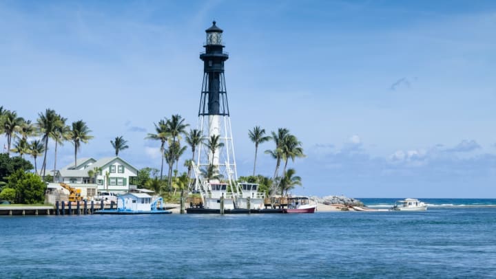 the Pompano beach lighthouse and the surrounding buildings and water from a distance