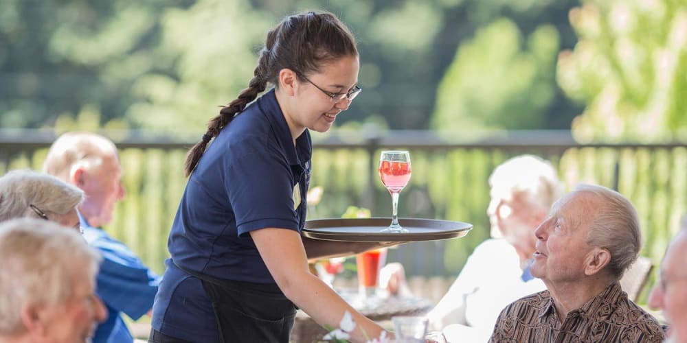 Friendly staff member talking to engaging senior gentleman at The Springs at Veranda Park in Medford, Oregon