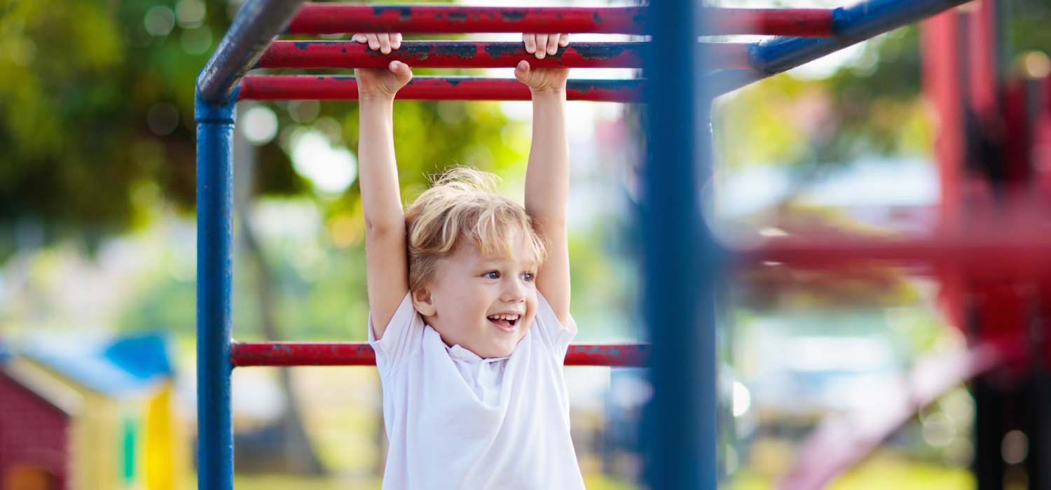 Kids play area with a hanging bar at Lakewood Apartments in Stockbridge, Michigan