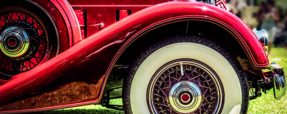 A red Rolls Royce with whitewall tires