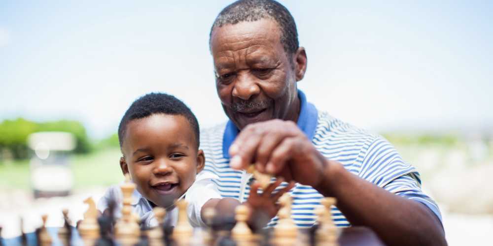 Resident playing chess with grandchild at Clearwater at The Arboretum in Austin, Texas