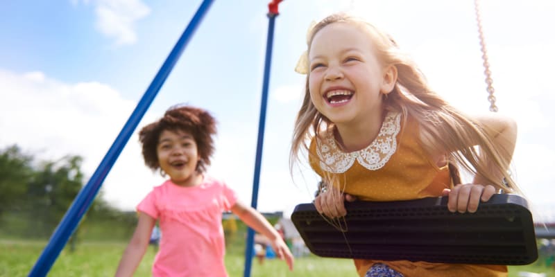 a couple of kids playing on a playground near Coral Sea Cove in Port Hueneme, California