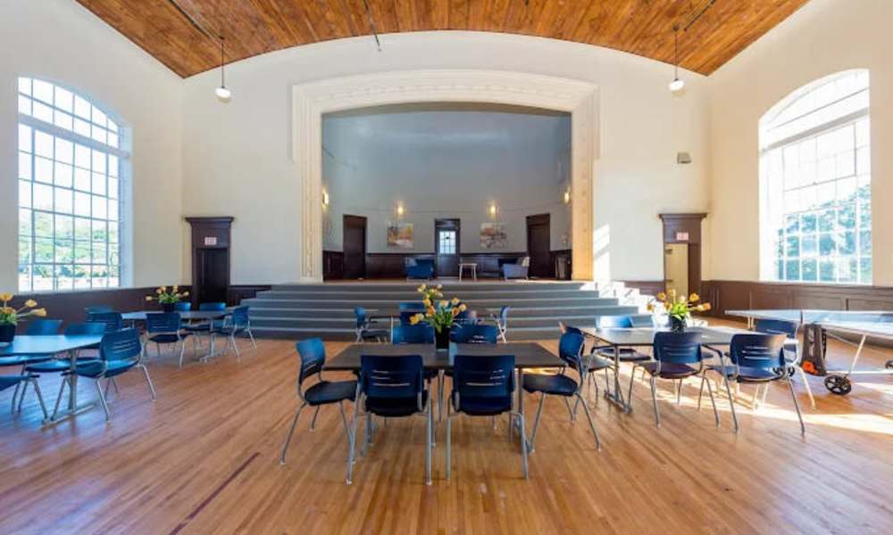 Community clubhouse with tables and stage at A.L. Miller Village in Macon, Georgia