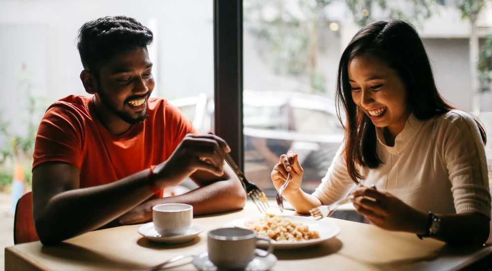 A happy couple having meals at their favorite restaurant near Warrick Trail Apartments in Newburgh, Indiana