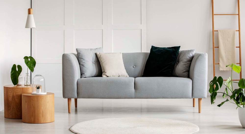Living room with grey color sofa at Independence Park Apartments in Canoga Park, California