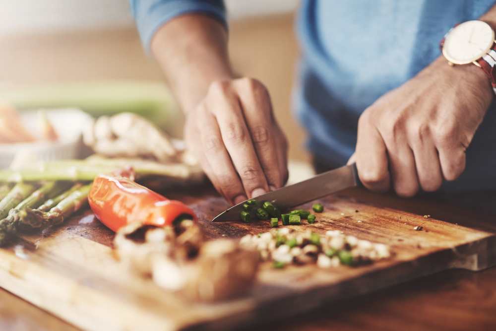 A man cooking a meal in his apartment at Wellington Apartments in Silverdale, Washington