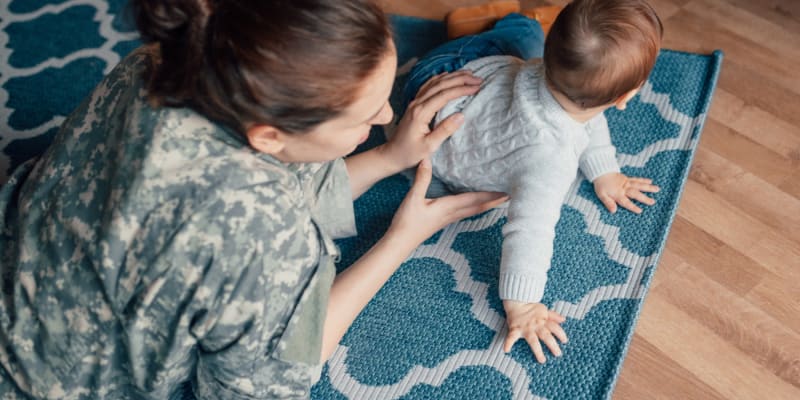 a resident with their infant on the floor Copper Canyon in Twentynine Palms, California