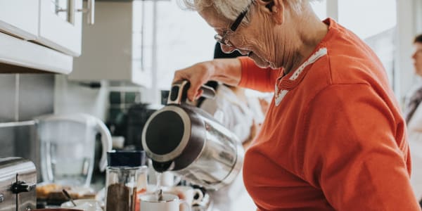 Resident pouring herself some water for a cup of tea at Wellington Meadows in Fort Atkinson, Wisconsin