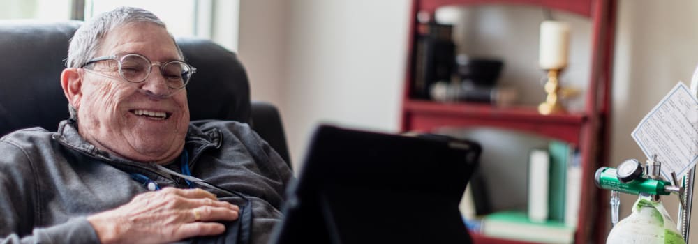 A resident looking at a tablet in his Stoney Brook apartment. 