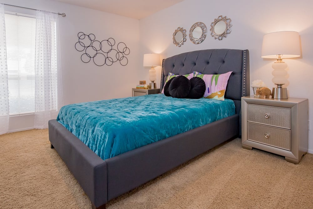 Model bedroom with bed and dresser at Windsail Apartments in Tulsa, Oklahoma
