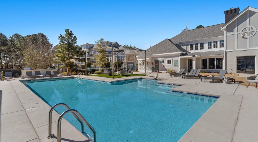 Sparkling swimming pool view with relaxing lounge chairs at Chandler At University Tower in Durham, North Carolina