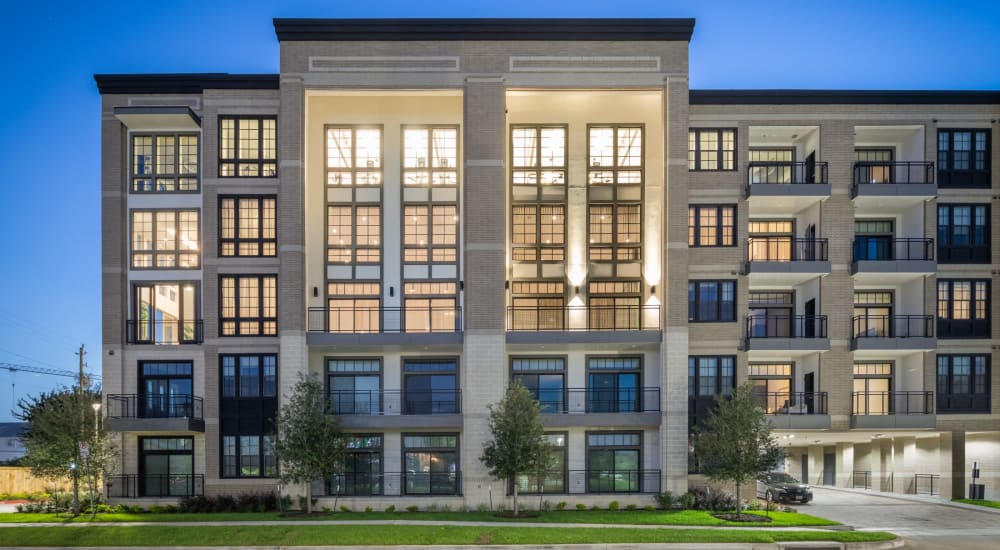 Exterior of townhomes at dusk surrounded by walkways and trees at Bellrock Sawyer Yards in Houston, Texas