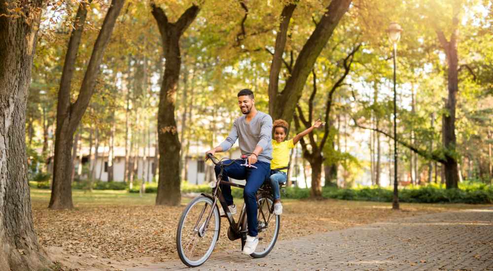 Resident with his kid riding bike near Cherokee Village in Dallas, Texas