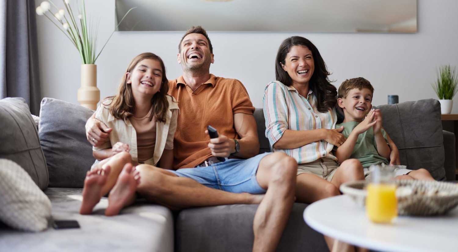 A family happily watching tv at Hawks Prairie Apartments in Lacey, Washington