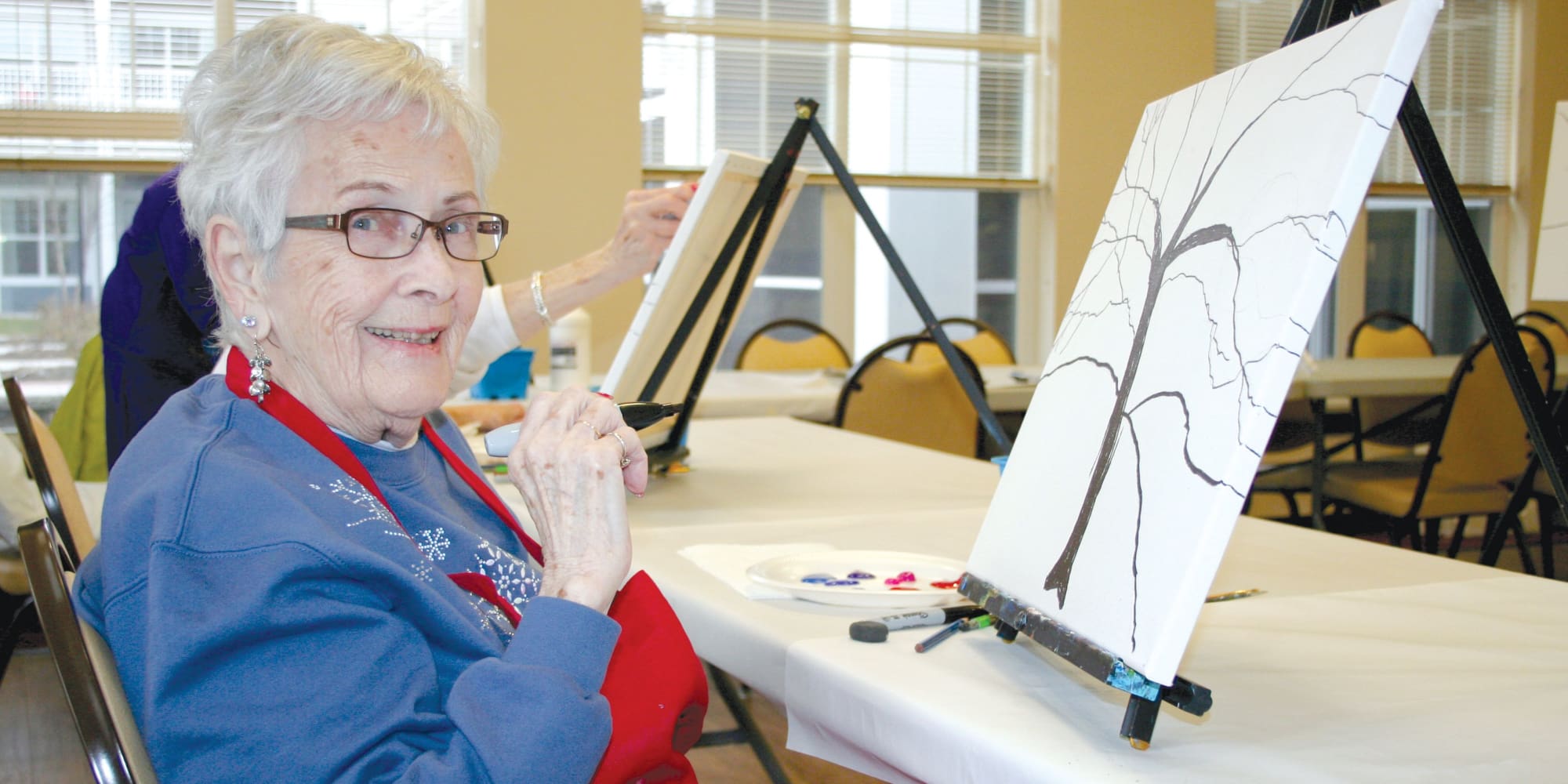 A resident painting a tree at Cypress Springs Gracious Retirement Living in Bradenton, Florida