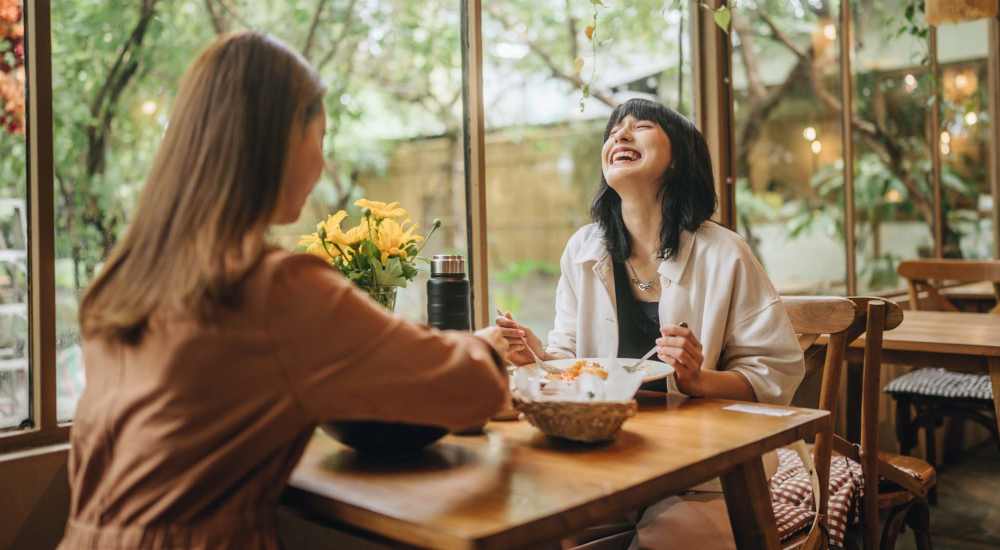 Friends enjoying food at a restaurant near Capitola Gardens in Capitola, California