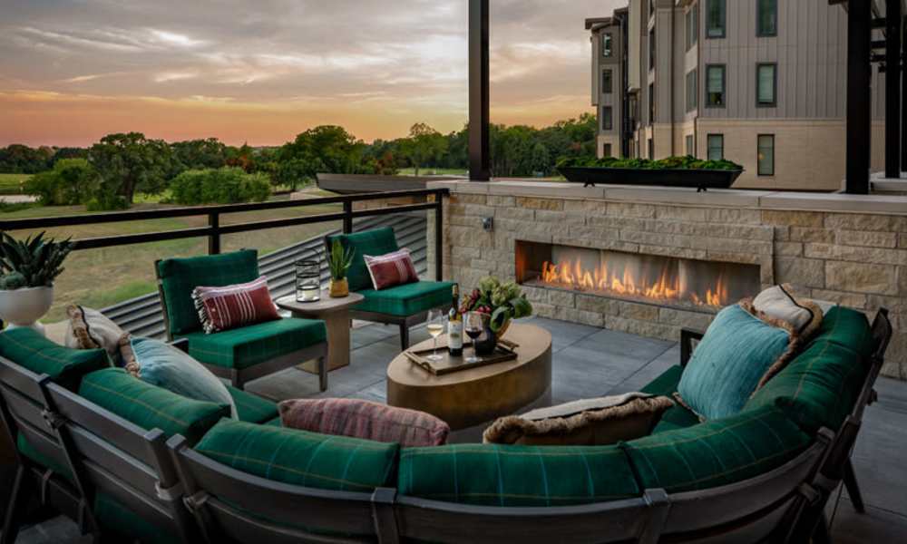 Exterior seating with fireplace at Touchmark at Emerald Lake in McKinney, Texas