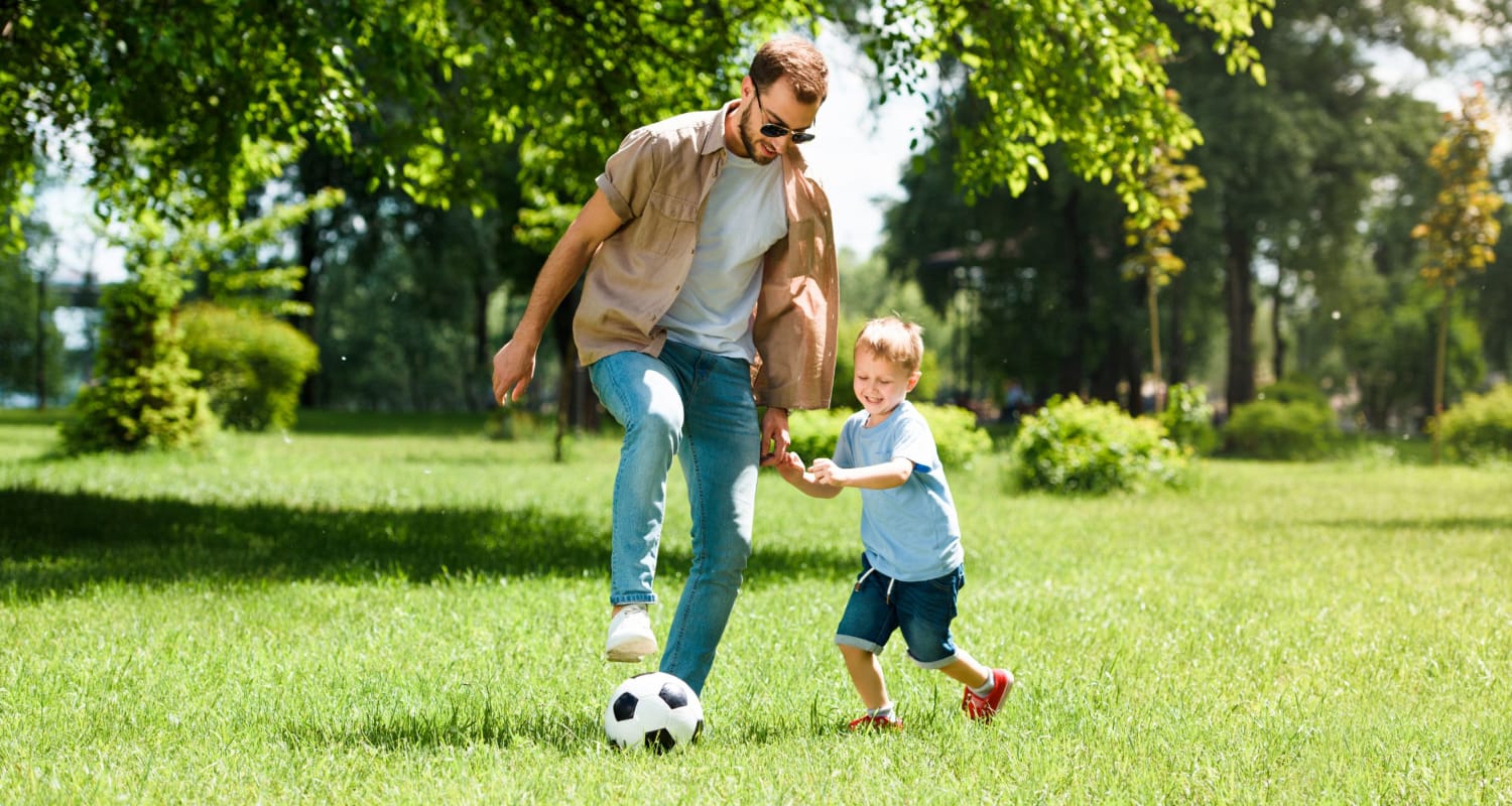 Resident father and son playing soccer at a park near Parks at Nexton in Summerville, South Carolina