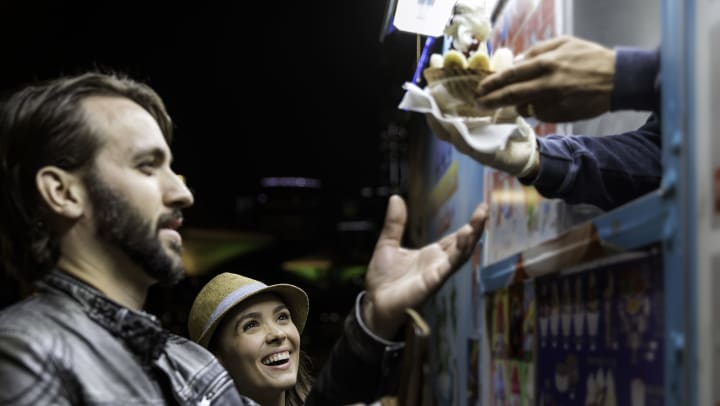 Customers receive ice cream product at the food truck at night
