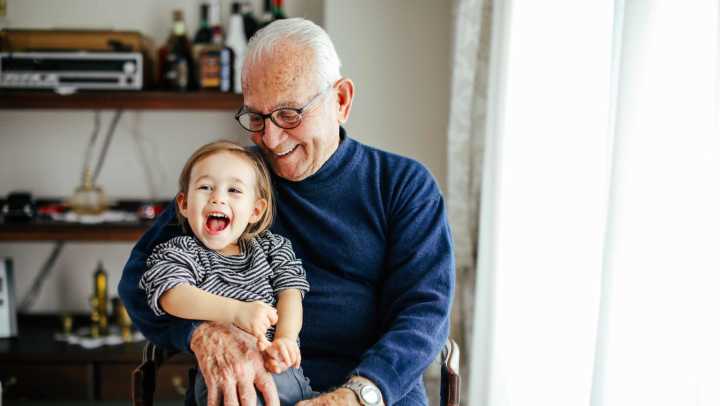 Older adult with young child seated indoors, {{location_name}} in {{location_city}}, {{location_state_name}}
