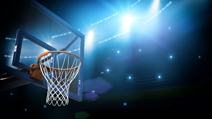 A basketball hoop under bright lights.
