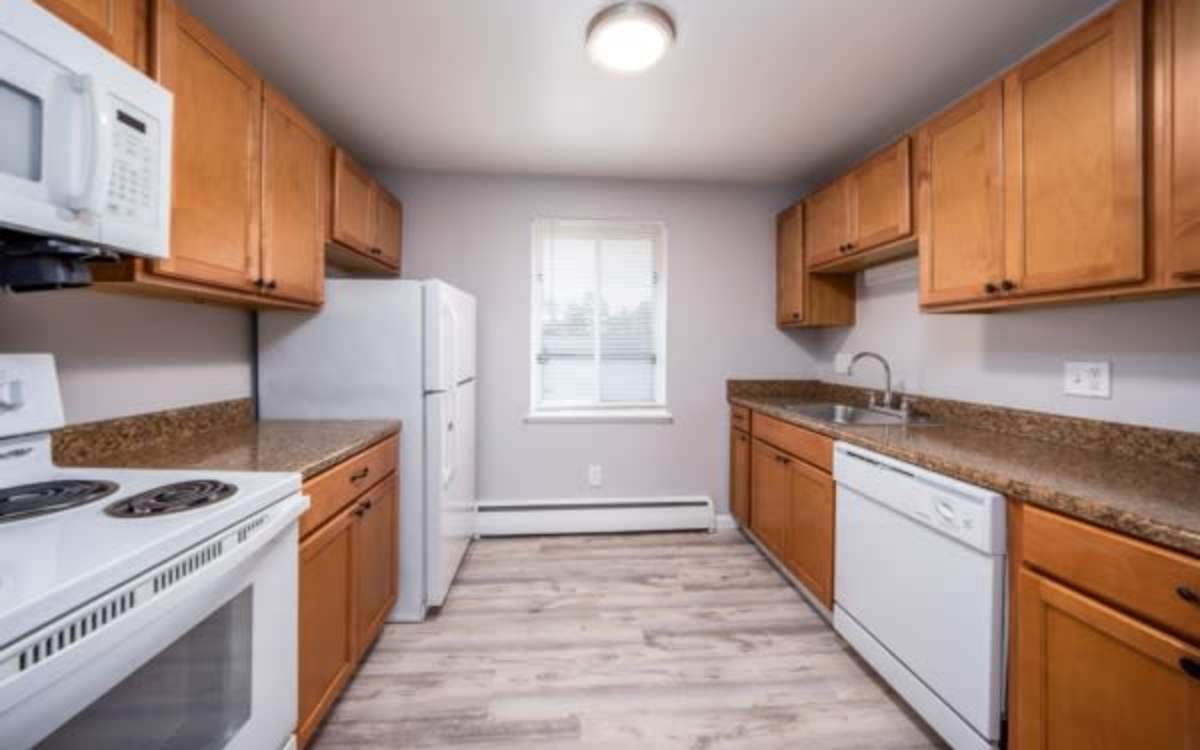 Kitchen with white appliances at Highland Bay Apartments in Rochester, New York