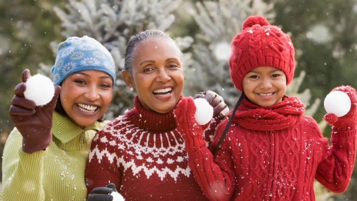 Three generations of woman including girl (6-7) playing in snow