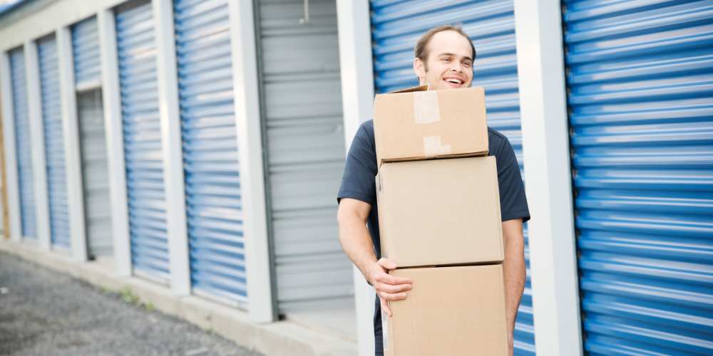 Man carrying storage boxes at Affordable Storage in Independence, Oregon