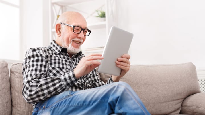 Senior man reading tablet