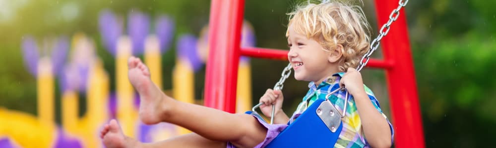 Child on swing at a park near Vivo Living Wilmington in Wilmington, North Carolina