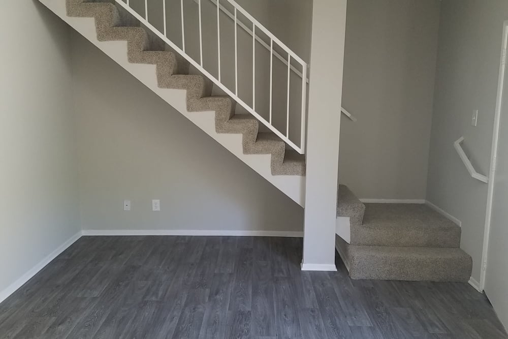 Hardwood floors leading to plush carpet on the upper floor staircase in model home at Sienna Heights Apartment Homes in Lancaster, California