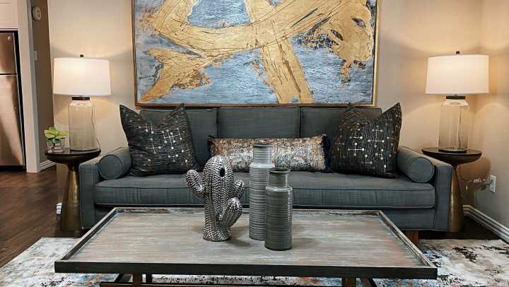 A modern living room featuring a comfortable couch, coffee table, and decorative art.