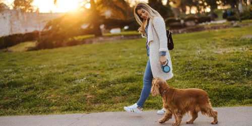 Resident taking her dog for a walk through a park near Comanche Hills in La Mesa, California
