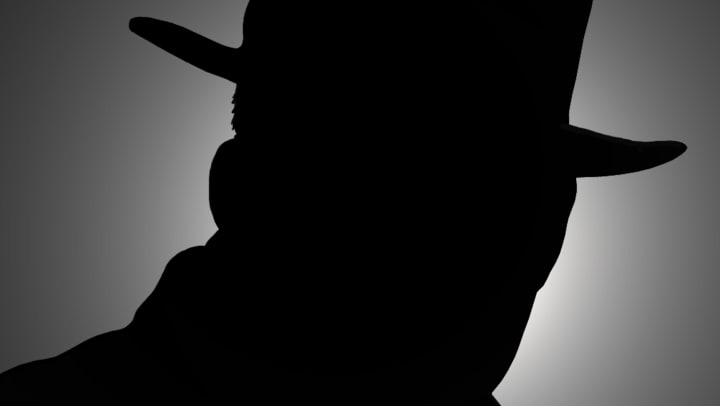 Silhouette of a person in a fedora. 