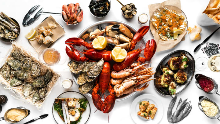Cooked crawfish and assorted other seafood photographed from above on a white table top.