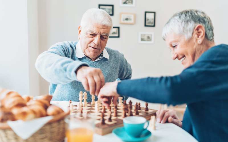 Two residents playing chess at The Pineapple House at Sapphire Lakes in Naples, Florida