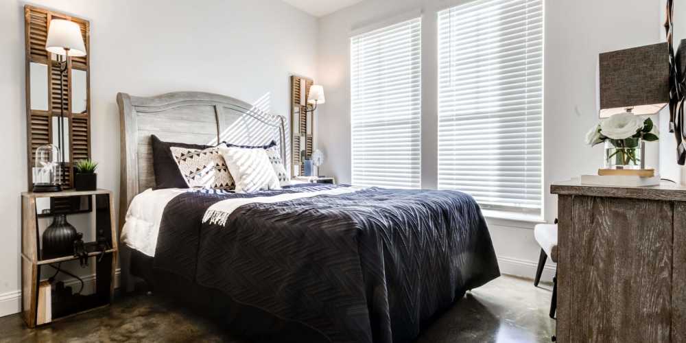 Bright bedroom with night stand, lamp and windows at Magnolia South in Holly Springs, North Carolina 