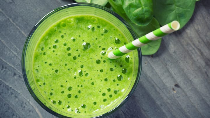 Spinach smoothie with matching green straw.